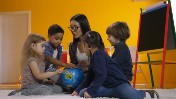 Profesor y niños discutiendo globo en el jardín de infantes — Vídeos de Stock