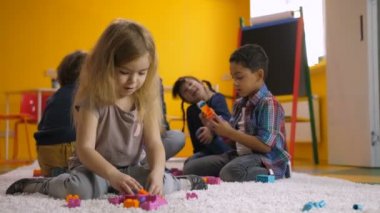 Okul öncesi kız renkli oyuncak bloklarla oynama