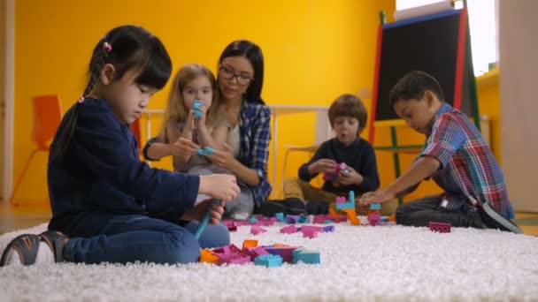 Asiatique petite fille jouer avec constructing blocs — Video