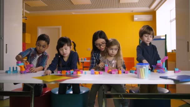 Niños jugando con bloques de construcción en el aula — Vídeos de Stock
