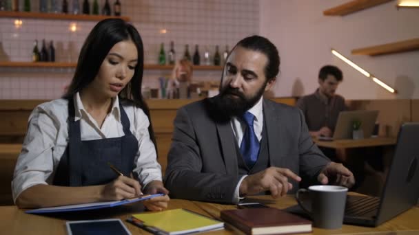 Gerente de café grave dando tarefas de trabalho para o empregado — Vídeo de Stock