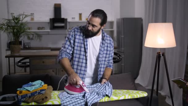 Papai ocupado com tarefas domésticas ajudando filho com lição de casa — Vídeo de Stock