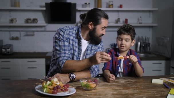 思いやりのあるお父さんと息子のおいしいフルーツのケバブを作る — ストック動画