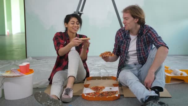 Happy couple eating pizza while making renovation — Stockvideo