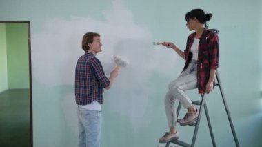 Cheerful diy couple doing makeover of new house