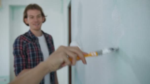 Tangan dengan cat kuas dinding lukisan di rumah baru — Stok Video