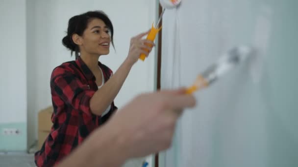 Счастливая семейная пара восстанавливает новую домашнюю роспись стены — стоковое видео