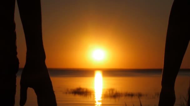 Silhouet van het paar toetreden overhandigt zonsondergang — Stockvideo