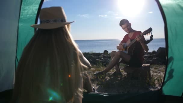 Man gitaar spelen en zingen aan meisje in de tent — Stockvideo