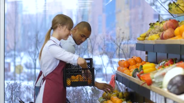 Eigenaren van kleine ondernemingen vullen fruit opslag rekken — Stockvideo