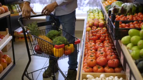 Muž tlačí nákupního košíku v supermarketu — Stock video