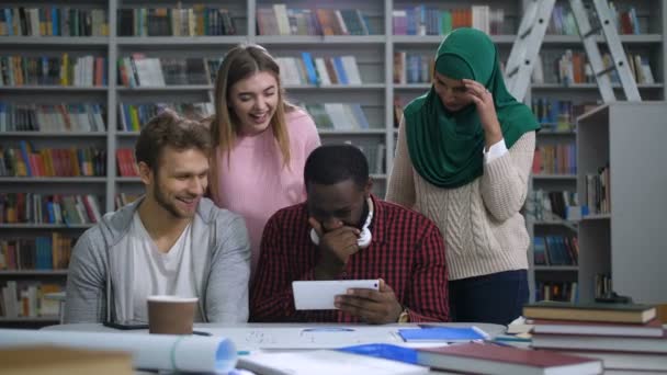 Estudantes diversos navegando conteúdo engraçado no tablet — Vídeo de Stock