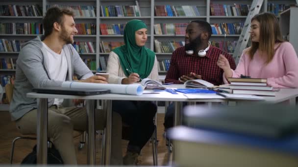 Amigos multirraciales trabajando en proyecto universitario — Vídeo de stock