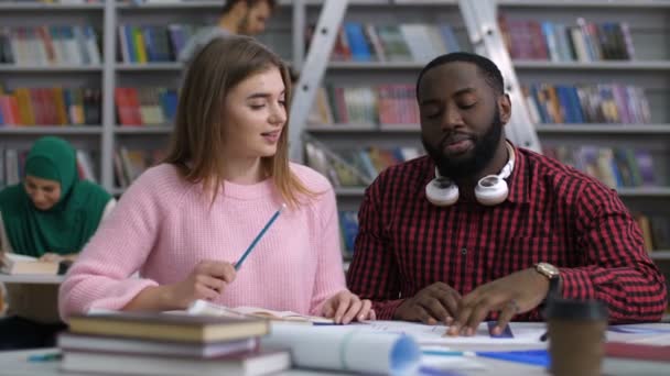 Többnemzetiségű diák tanul együtt könyvtár — Stock videók
