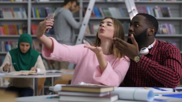 Internationella studenter tar en selfie i biblioteket — Stockvideo