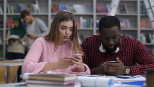Різноманітні студенти обмінюються онлайн-контентом по телефону — стокове відео
