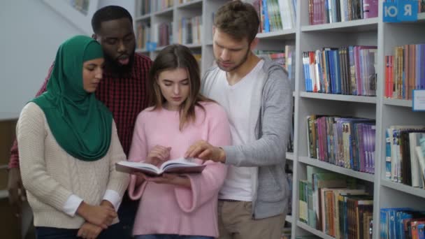 Diverse Studenten stehen neben Bücherregalen — Stockvideo