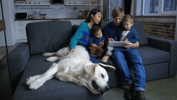 Família diversa com rede de filhotes no tablet pc — Vídeo de Stock