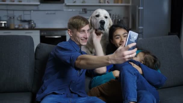 Famiglia multietnica con cane da compagnia in posa per selfie — Video Stock