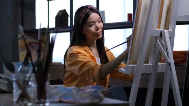 Artista femenina haciendo una pintura en un estudio de arte — Vídeos de Stock