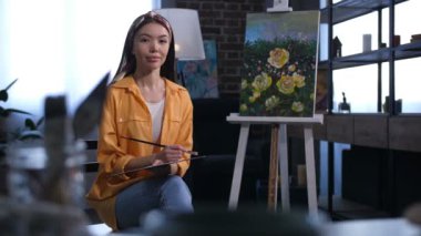 Çekici Asyalı kadın sanatçı tuval oturan