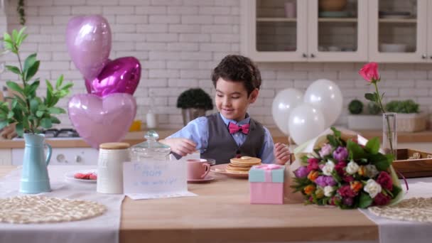 Pequeño hijo lindo sirviendo mesa de desayuno para la madre — Vídeos de Stock