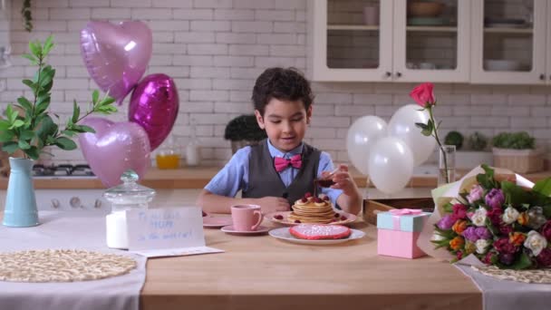열심히 팬케이크에 시럽을 붓는 귀여운 소년 — 비디오