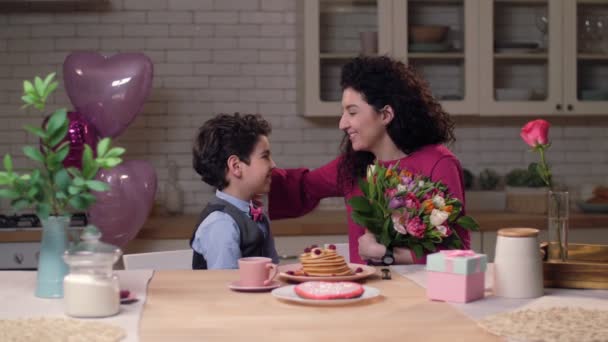 Hijo cariñoso dando flores festivas a mamá feliz — Vídeos de Stock