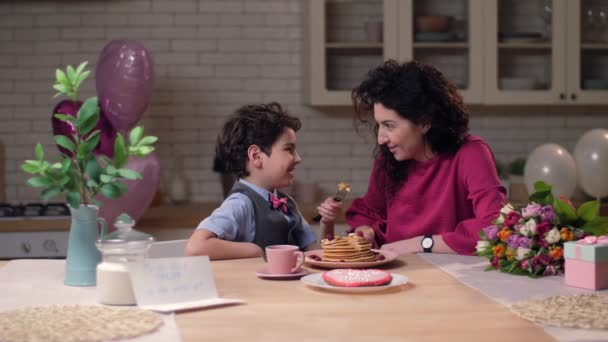 Caring arab son feeding mom with pancakes — Stock Video