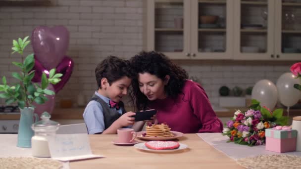 Mãe com filho assistindo vídeo engraçado no telefone inteligente — Vídeo de Stock