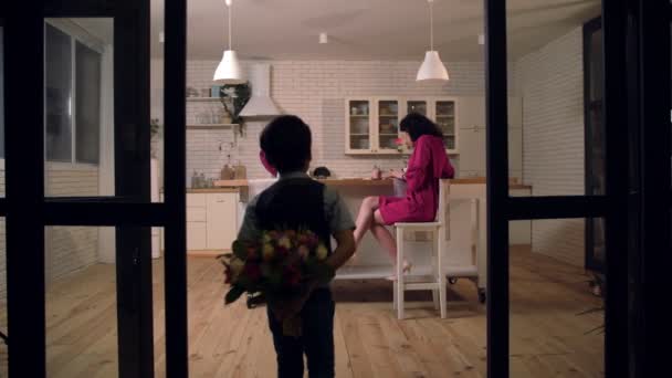 儿子惊奇的母亲与花在厨房 — 图库视频影像