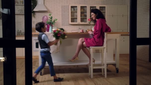Zorgzame zoon bezorgt boeket bloemen aan moeder — Stockvideo