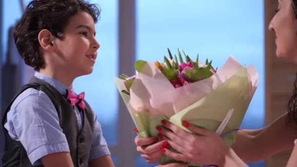 Primer plano adorable hijo presentando flores a mamá — Vídeos de Stock