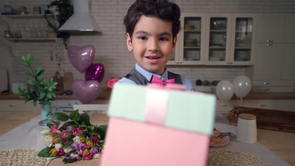 Retrato de niño pequeño ofreciendo caja de regalo en la cámara — Vídeos de Stock