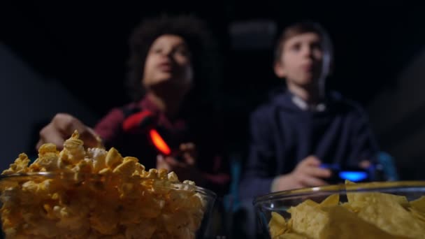 Desfocado adolescente gamers comer pipocas e jogar jogo — Vídeo de Stock