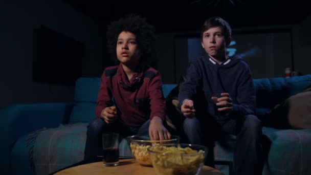 Bang tieners eten popcorn tijdens horrorfilm — Stockvideo
