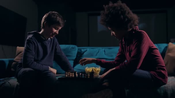 Diverse teen boys moving pieces on chess board — Stock Video
