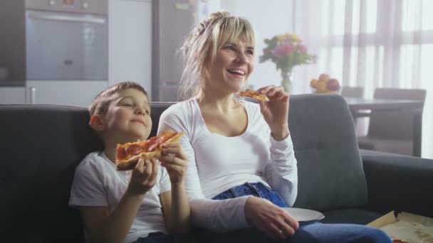 Keluarga menonton acara TV komik dan makan pizza — Stok Video