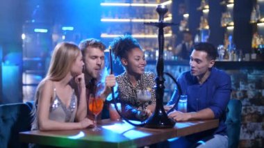 Sigara nargile gece kulübünde konuşan mutlu arkadaşlar