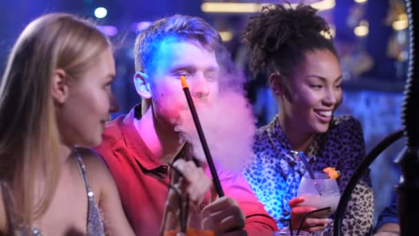 Радісні друзі розважаються в диско-барі з кальяном — стокове відео