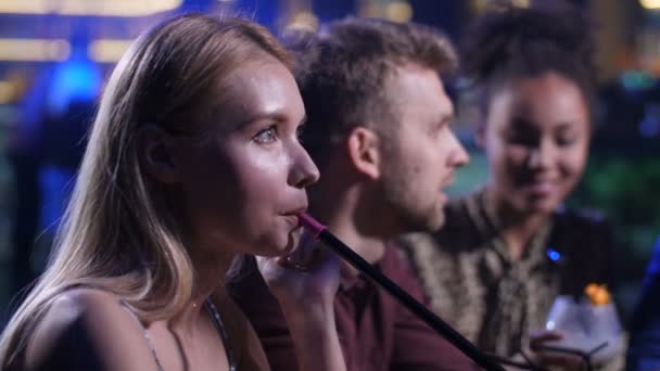 Розслаблені друзі насолоджуються курінням кальяну в барі — стокове відео