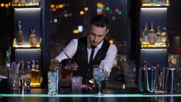 Barman cocktail aan glas gieten in staaf — Stockvideo