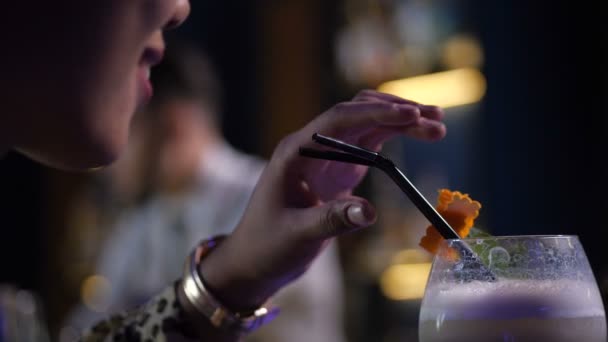 Крупный план улыбающейся женщины, пьющей коктейль в баре — стоковое видео