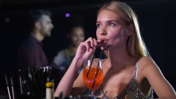 Verveeld alleen vrouw drinken cocktail in nachtclub — Stockvideo