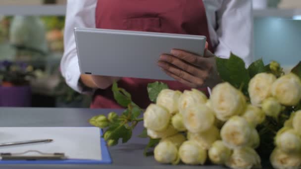 Kvinna florist händer med hjälp av tablett för att ta order — Stockvideo