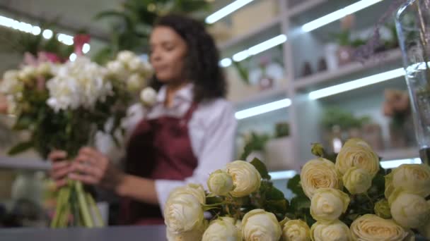 Floristería joven haciendo hermoso arreglo de flores — Vídeo de stock