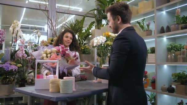 Fleuriste donnant prêt création florale au client — Video