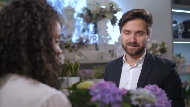 Snygg blomsteraffär klient väljer anläggning för gåva — Stockvideo