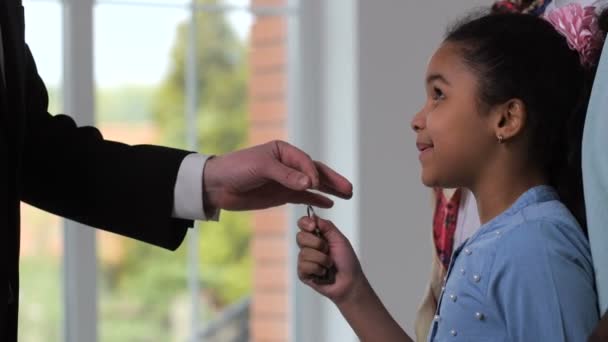 Happy little girl taking house keys from realtor — Stock Video