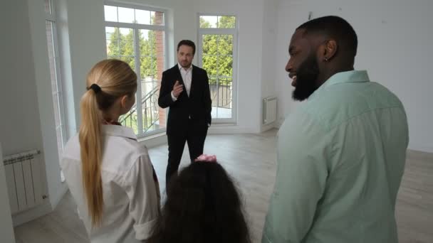 Família positiva olhando em torno de casa nova para venda — Vídeo de Stock